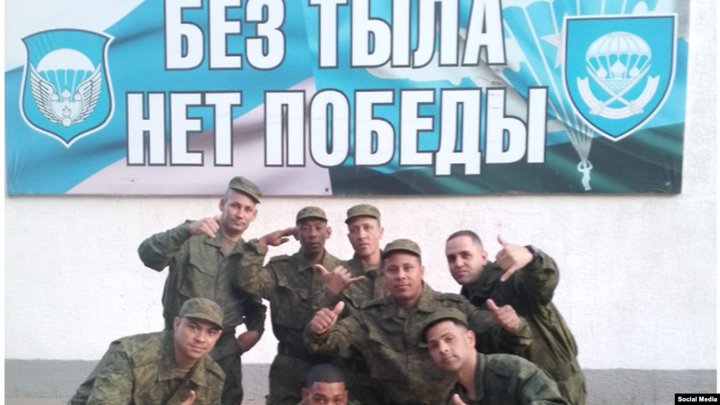 Cubanos en el Regimiento 137 de los paracaidistas rusos.&nbsp;El cartel, escrito en idioma ruso y que indica "Sin retarguardia no hay victoria", incluye el emblema del 137 Regimiento de Paracaidistas (der.)&nbsp;y a la izq. de la&nbsp;106 División Aerotransportada de las Tropas de Paracaidistas.&nbsp;(Cortesía Alain Paparazzi cubano).