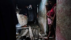 Luzanne de la Castro y su hija se encuentran en la puerta de su casa dañada por el huracán Ian en Pinar del Río, Cuba, 27 de septiembre de 2022. REUTERS/Alexandre Meneghini