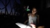 Una niña hace la tarea con la luz de su celular en medio de un apagón en La Habana, Cuba. (REUTERS/Alexandre Meneghini/Archivo)