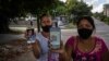 Servilia Pedroso (der.), madre del estudiante de 18 años Eloy Bárbaro Cardoso, y Yaquelin Cruz, madre de Dariel Cruz, dos manifestantes del 11J en La Güinera, muestran sus fotos. (AP/Ramón Espinosa) 