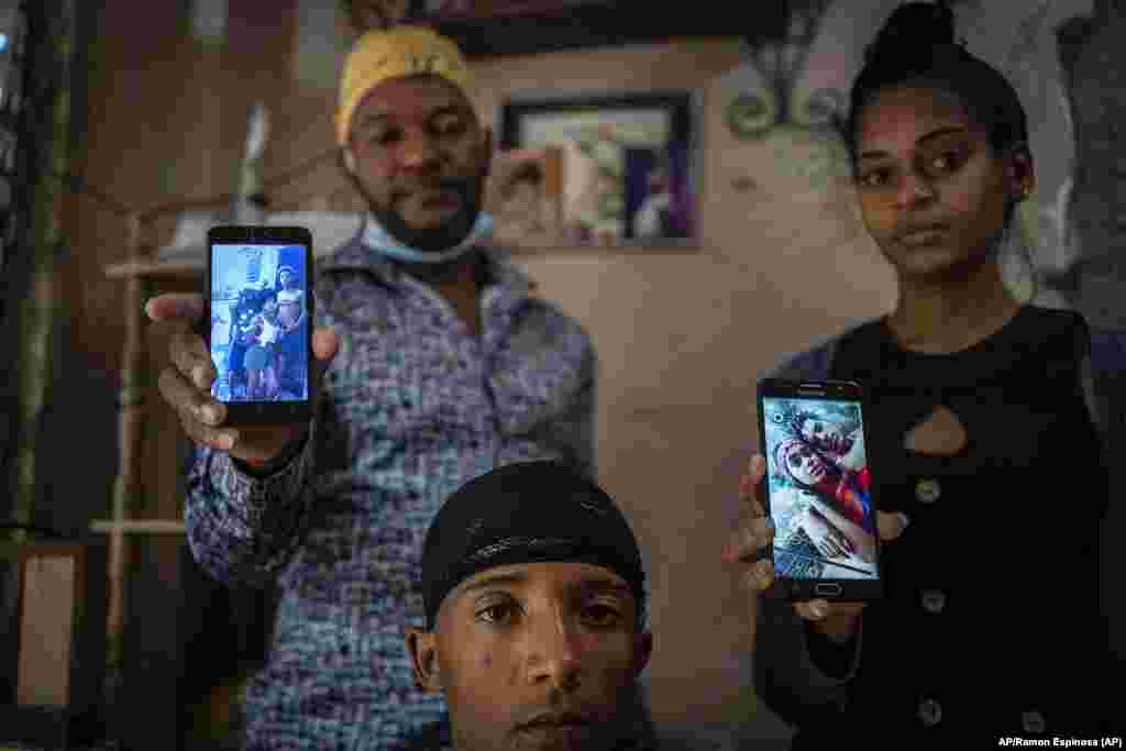 Odlanier Santiago Rodríguez, al centro, quien fue acusado de participar en las protestas de julio del año pasado y fue liberado tras 22 días en prisión; posa junto a su tío Emilio Román, a la izquierda, y la nuera de éste, María Carla Milán Ramos, y muest