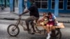 Un hombre transporta niños en su triciclo, en La Habana, en medio de la nueva pandemia de coronavirus. (Foto AP / Ramón Espinosa)